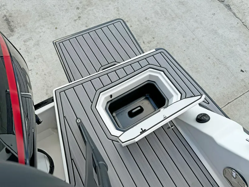 Slide: The Image of 2024 Starcraft SVX 230 OB boat deck with storage compartment, featuring sleek gray design. - 26