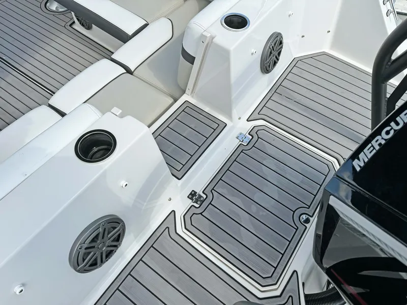 Slide: The Image of 2024 Starcraft SVX 230 OB boat interior with seating, speakers, and Mercury engine. - 27