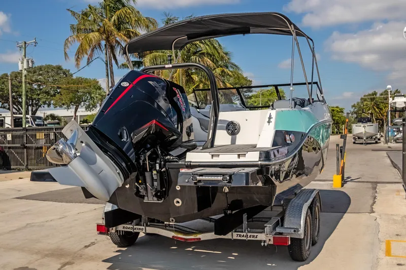 Slide: The Image of 2024 Starcraft SVX 230 OB boat on trailer, parked outdoors under sunny skies. - 4