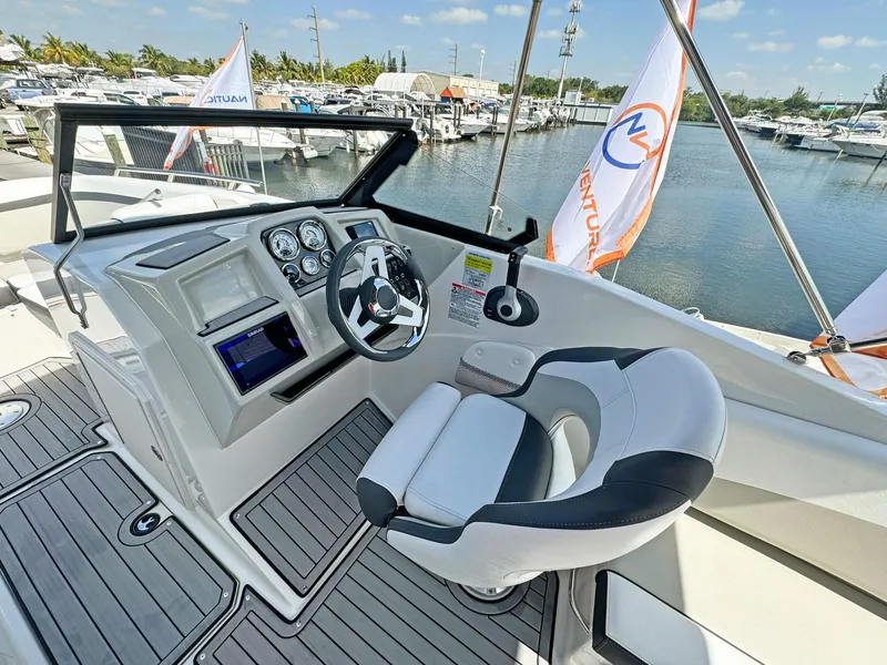 Slide: The Image of 2024 Starcraft SVX 230 OB boat cockpit with modern steering and controls at marina. - 8