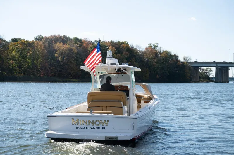 Slide: The Image of 2016 Hunt Yachts 32 Center Console with tan seating and canopy on a sunny day. - 10