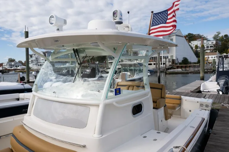 Slide: The Image of 2016 Hunt Yachts 32 Center Console with American flag, docked in a marina. - 15