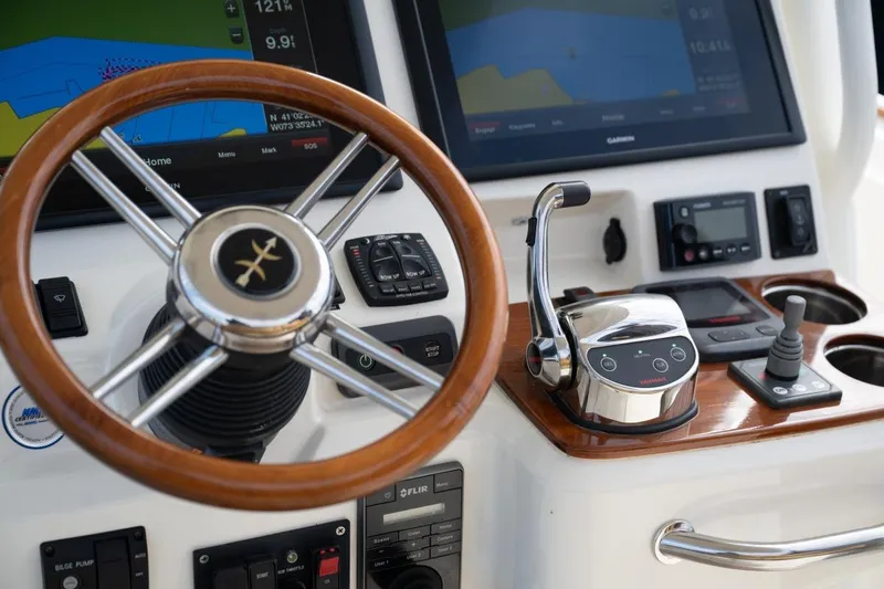 Slide: The Image of 2016 Hunt Yachts 32 Center Console docked, featuring American flag and marina backdrop. - 16