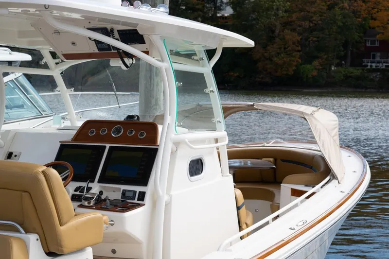Slide: The Image of 2016 Hunt Yachts 32 Center Console helm with dual navigation screens and wooden accents. - 21