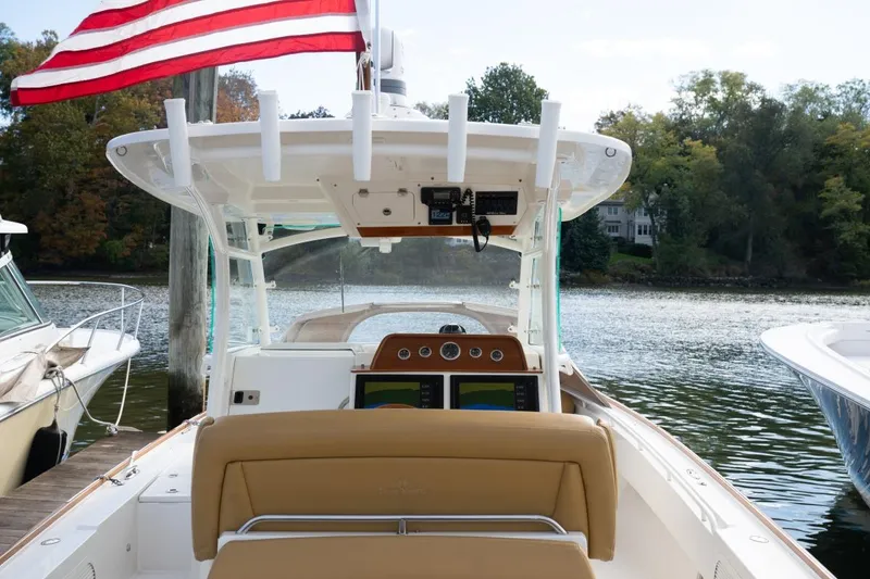 Slide: The Image of 2016 Hunt Yachts 32 Center Console on water, featuring tan seating and American flag. - 26