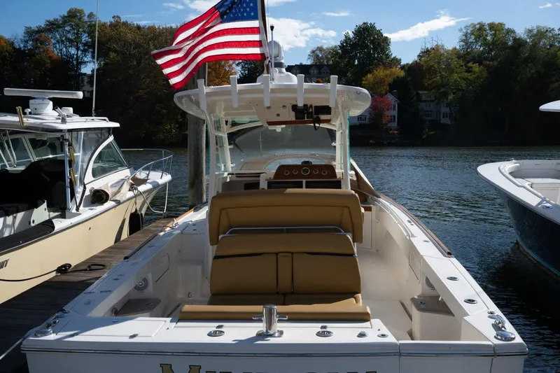 Slide: The Image of 2016 Hunt Yachts 32 Center Console at dock, American flag, serene waterfront setting. - 27