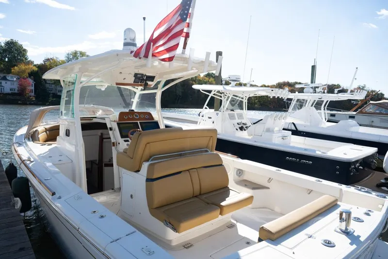 Slide: The Image of 2016 Hunt Yachts 32 Center Console with tan seating, docked on calm water. - 34