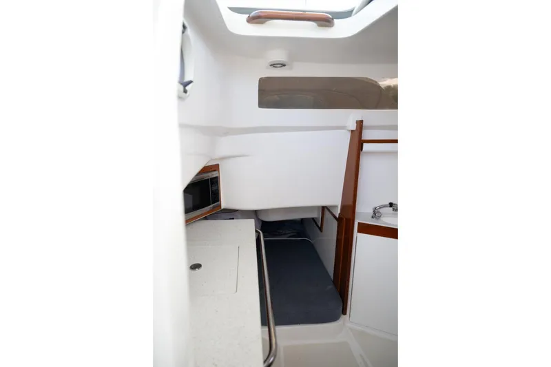 Slide: The Image of Interior of 2016 Hunt Yachts 32 Center Console, featuring a compact sink and wooden accents. - 44