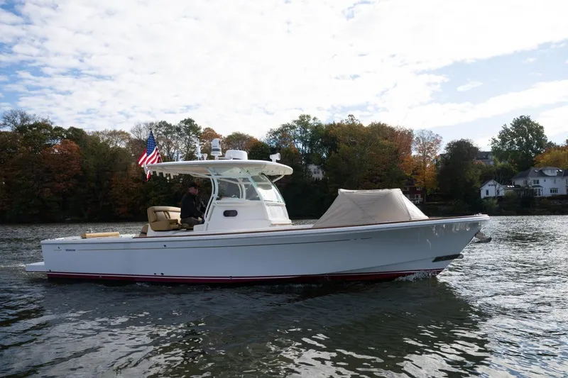 Slide: The Image of 2016 Hunt Yachts 32 Center Console cruising on a scenic waterway with American flag. - 7