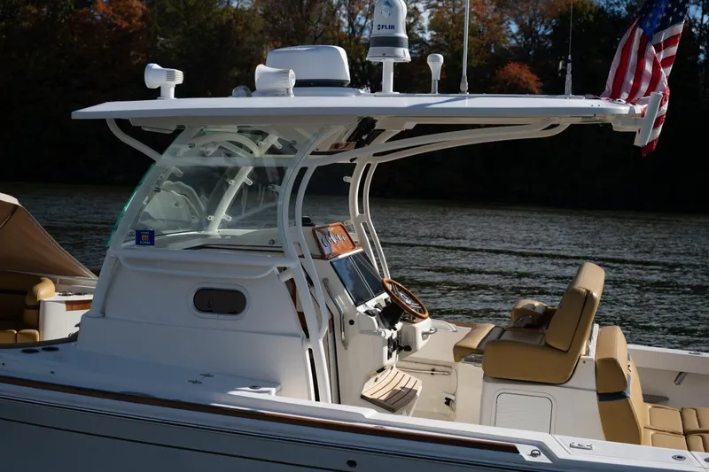 Slide: The Image of 2016 Hunt Yachts 32 Center Console on serene water, featuring tan seating. - 12