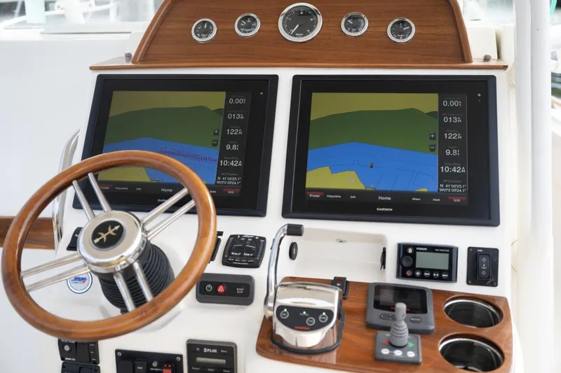 Slide: The Image of 2016 Hunt Yachts 32 Center Console helm with wooden steering wheel and navigation controls. - 17