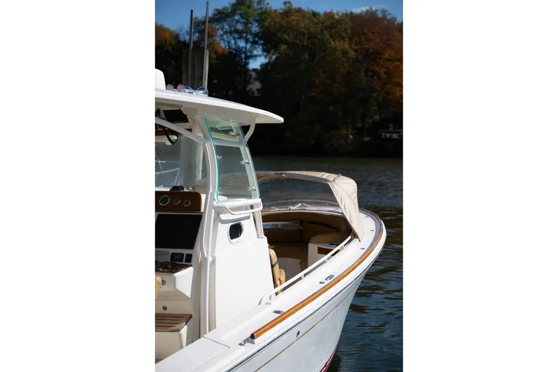 Slide: The Image of 2016 Hunt Yachts 32 Center Console docked, featuring tan seating and American flag. - 28