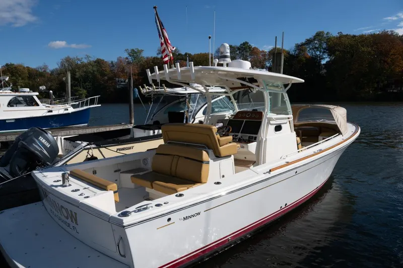 Slide: The Image of 2016 Hunt Yachts 32 Center Console docked, featuring sleek design and American flag. - 30