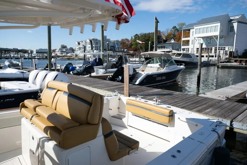 Slide: The Image of 2016 Hunt Yachts 32 Center Console docked, featuring tan seating and American flag. - 35