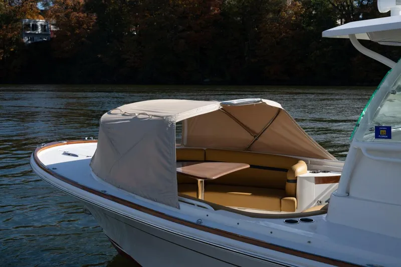 Slide: The Image of 2016 Hunt Yachts 32 Center Console on serene water, featuring a shaded seating area. - 41