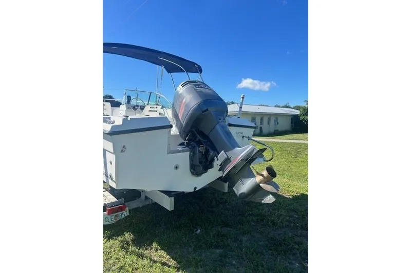Slide: The Image of 2000 Angler Dual Console boat with outboard motor on grassy area. - 3