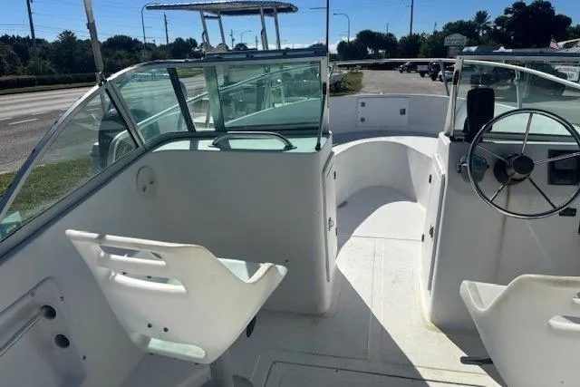 Slide: The Image of 2000 Angler Dual Console boat interior with steering wheel and seating, viewed from the deck. - 5
