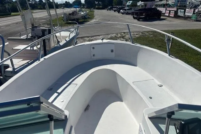 Slide: The Image of 2000 Angler Dual Console boat with open bow seating, parked near a road. - 6