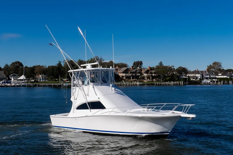 The Image of 2007 Luhrs Tournament 360 Open boat cruising on a sunny day near waterfront homes. - 1