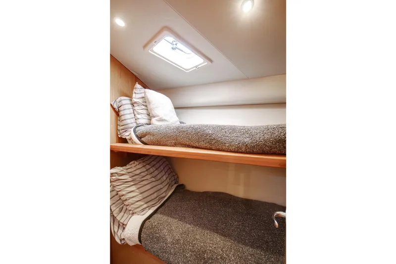 Slide: The Image of 2007 Luhrs Tournament 360 Open cabin with cozy bunk beds and soft lighting. - 14
