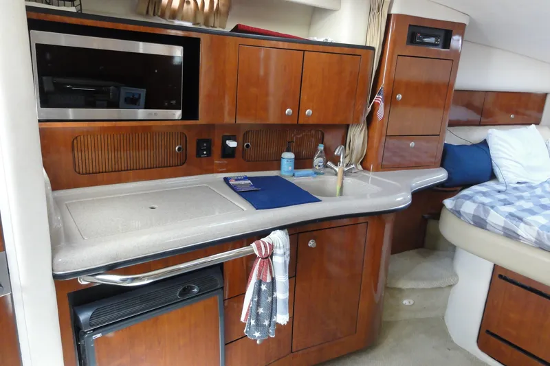Slide: The Image of Interior of 2007 Sea Ray 320 Sundancer with kitchenette and cozy sleeping area. - 17