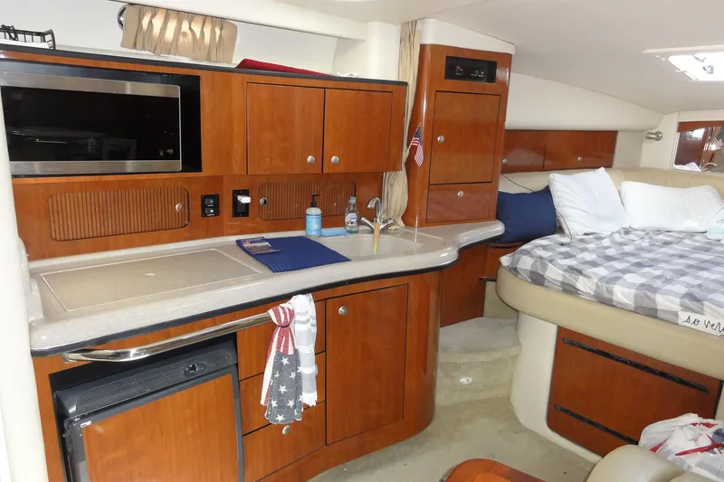 Slide: The Image of 2007 Sea Ray 320 Sundancer cabin with kitchenette and cozy sleeping area. - 19