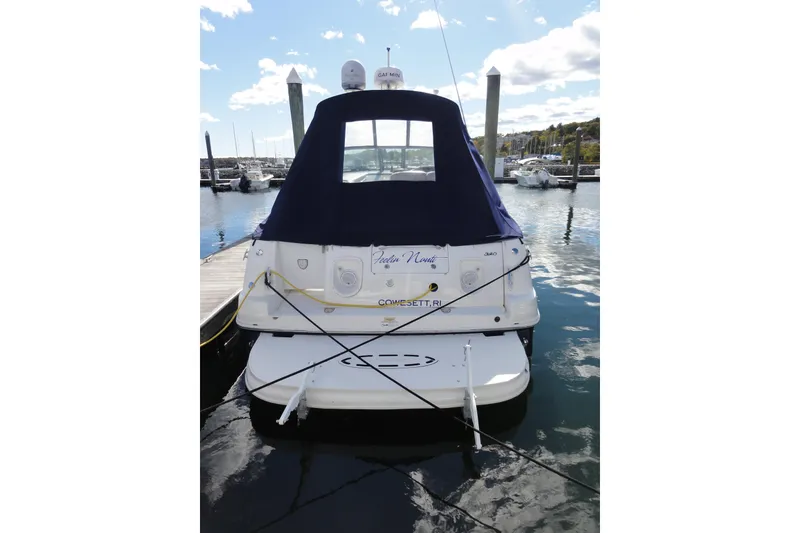 Slide: The Image of 2007 Sea Ray 320 Sundancer docked at marina, rear view with blue cover. - 2