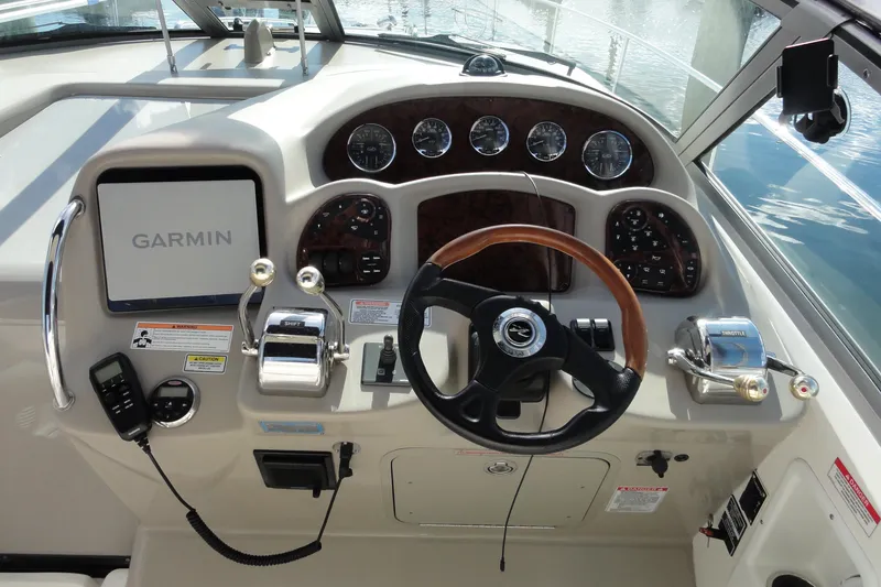 Slide: The Image of 2007 Sea Ray 320 Sundancer helm with Garmin display and wood-accented steering wheel. - 8