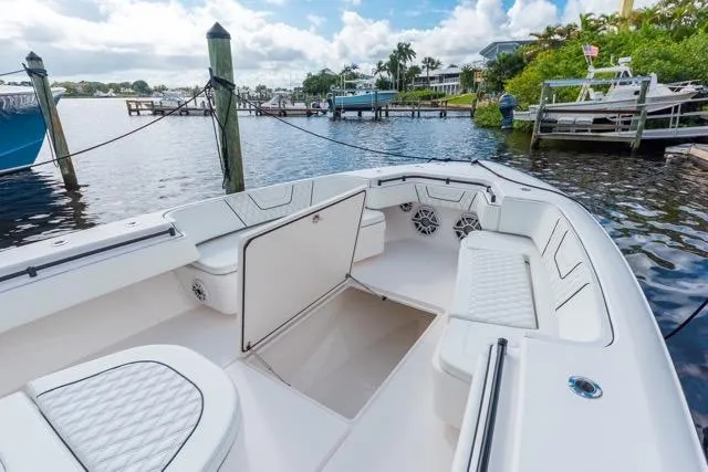 Slide: The Image of 2020 Contender 44 ST boat interior with helm, seats, and navigation screens at a marina. - 10