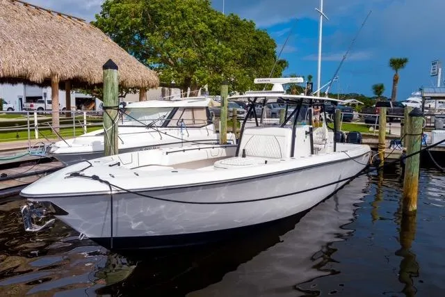 Slide: The Image of 2020 Contender 44 ST boat with spacious seating, docked at a marina under a cloudy sky. - 11