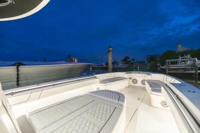 Slide: The Image of Four powerful outboard engines on a 2020 Contender 44 ST boat, docked with red lighting. - 17