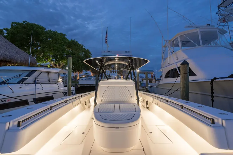 Slide: The Image of 2020 Contender 44 ST boat docked at marina with thatched roof hut in background. - 2