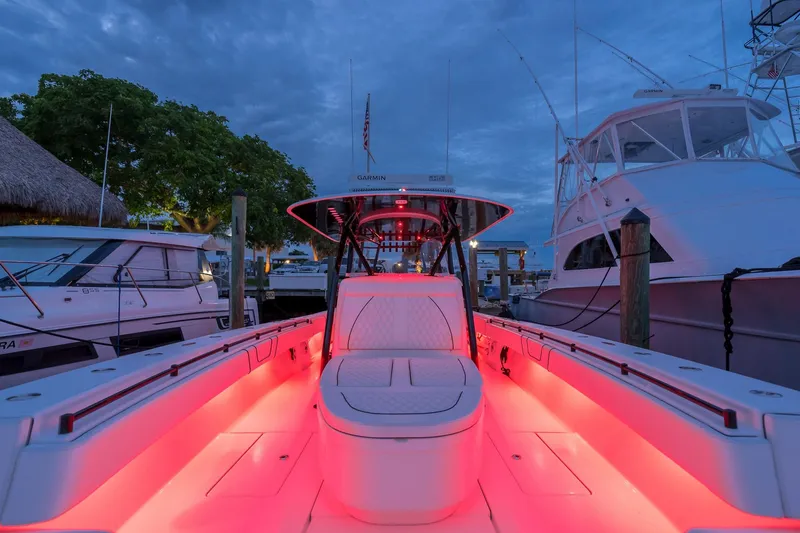 Slide: The Image of 2020 Contender 44 ST boat with vibrant red deck lighting at marina. - 6
