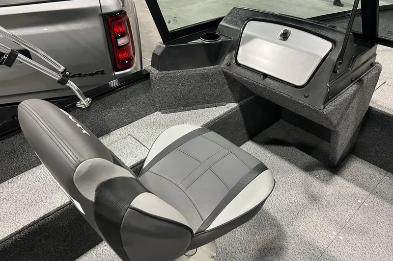 Slide: The Image of 2024 Lund 1650 Angler Sport interior with gray seating and storage compartment. - 12