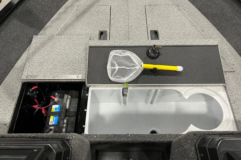 Slide: The Image of 2024 Lund 1650 Angler Sport interior with battery compartment and fishing net. - 14