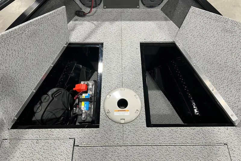 Slide: The Image of 2024 Lund 1650 Angler Sport boat interior storage compartments with battery and wiring. - 15