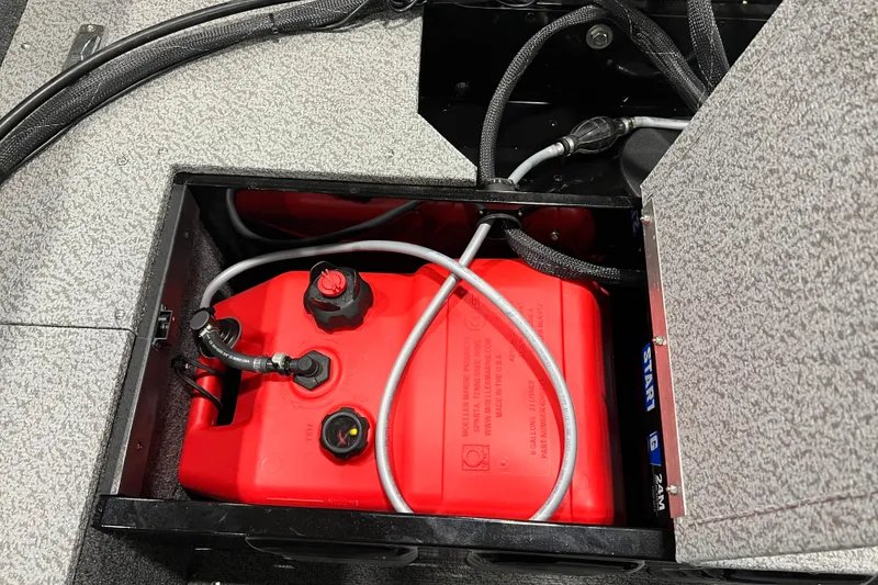 Slide: The Image of 2024 Lund 1650 Angler Sport's red fuel tank compartment with cables and connectors. - 6