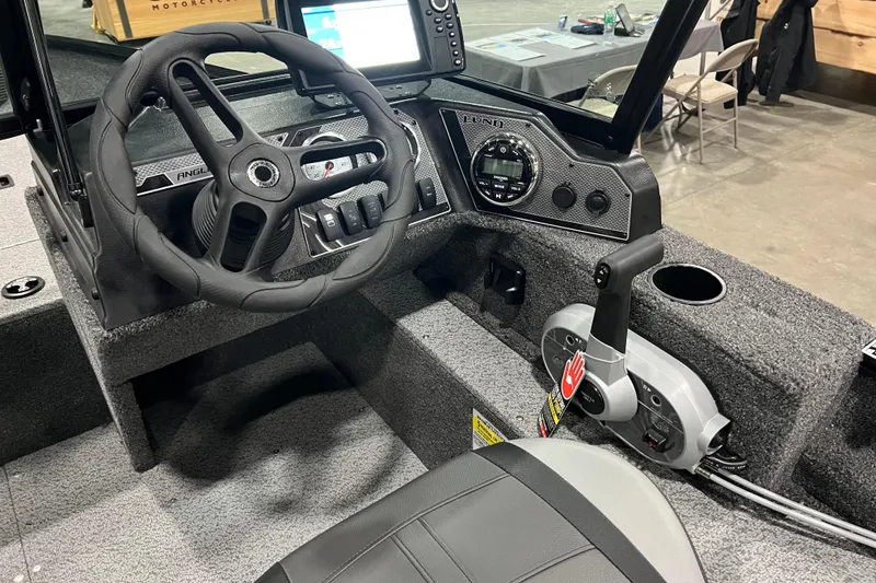 Slide: The Image of 2024 Lund 1650 Angler Sport boat interior with steering wheel and control panel. - 8