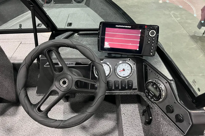 Slide: The Image of 2024 Lund 1650 Angler Sport dashboard with steering wheel and Humminbird fish finder. - 9