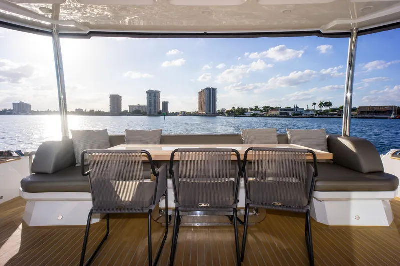 Slide: The Image of Luxury yacht Pearl 80, 2020 model, with elegant outdoor seating and scenic waterfront view. - 28