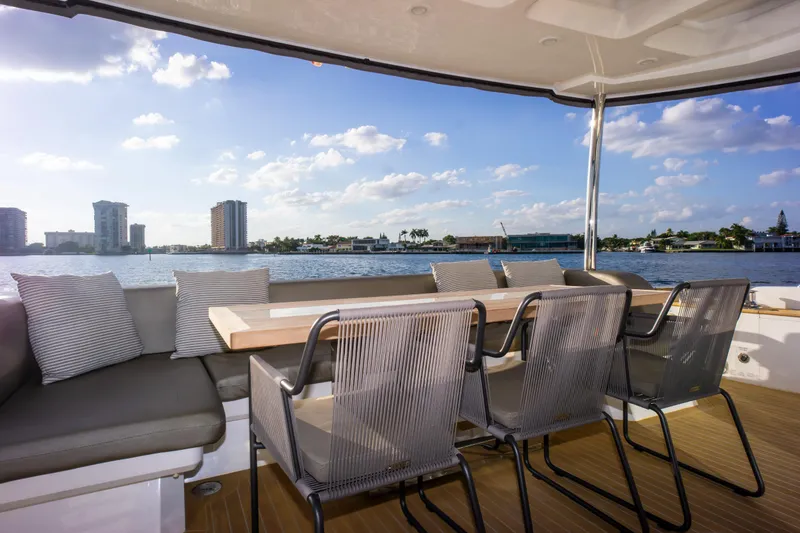 Slide: The Image of Luxurious Pearl 80 yacht deck with seating, overlooking a scenic waterfront view. - 29