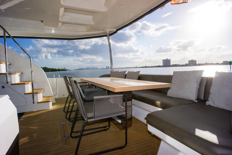Slide: The Image of Luxurious Pearl 80 yacht deck with seating, table, and scenic ocean view, 2020 model. - 30