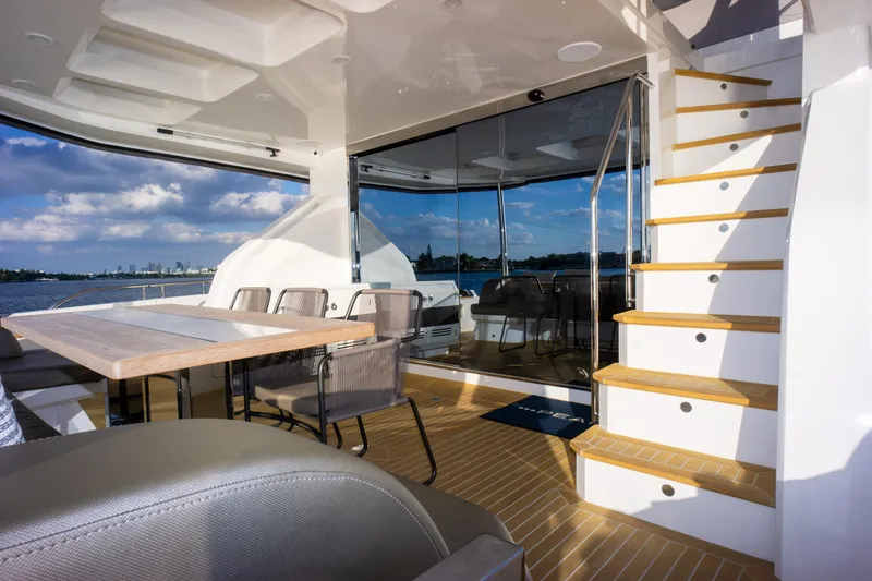 Slide: The Image of Luxurious Pearl 80 yacht interior, featuring elegant seating, wooden stairs, and scenic ocean views. - 31