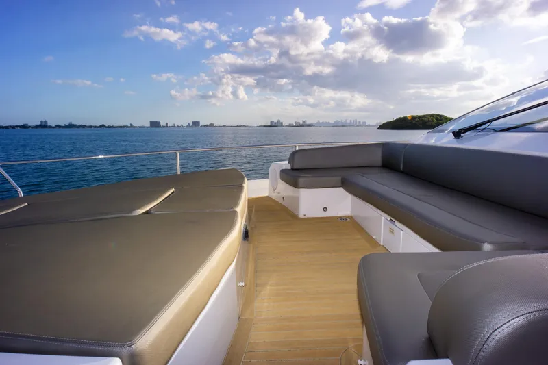 Slide: The Image of Luxurious Pearl 80 yacht deck with seating, overlooking serene ocean and skyline, 2020 model. - 35