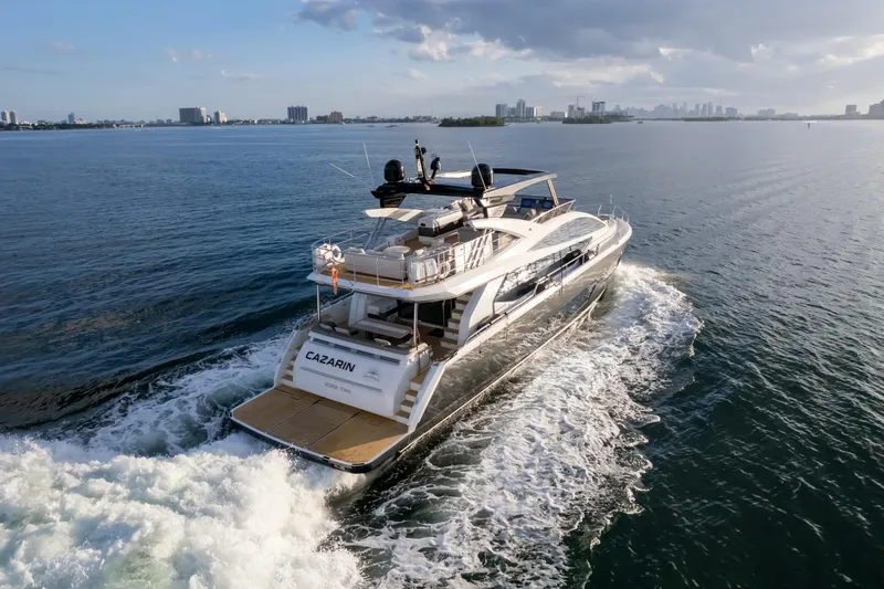 Slide: The Image of Luxury Pearl 80 yacht cruising on open water, 2020 model, city skyline in background. - 6