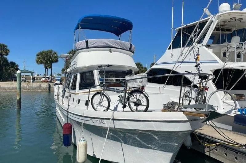 The Image of 1988 Albin 34 Cruiser docked with bicycles on deck, under clear blue sky. - 0