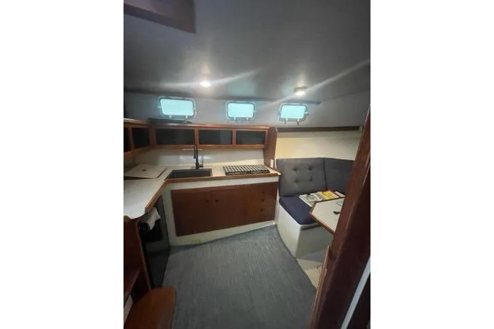 Slide: The Image of Interior of 1988 Albin 34 Cruiser with cozy seating and compact kitchen area. - 11