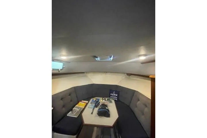 Slide: The Image of Cozy interior of 1988 Albin 34 Cruiser with cushioned seating and table. - 12