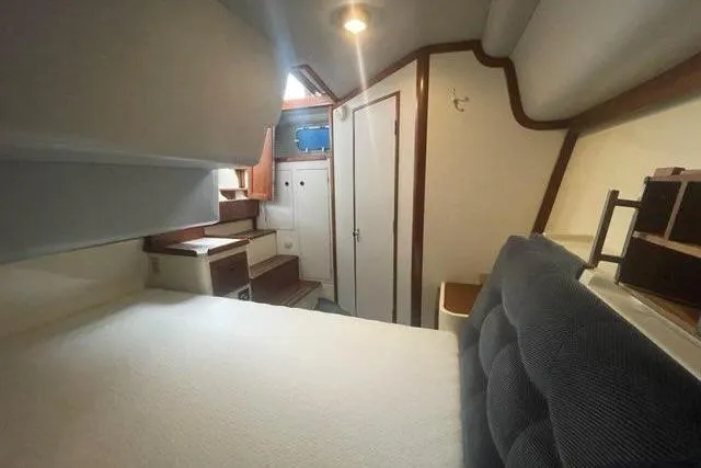 Slide: The Image of Interior of 1988 Albin 34 Cruiser, featuring cozy cabin with bed and wooden accents. - 19