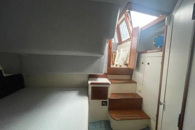 Slide: The Image of Interior of 1988 Albin 34 Cruiser, featuring cabin stairs and cozy sleeping area. - 22